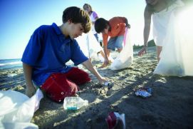 Kinder sammeln M&uuml;ll am Strand ein.