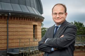 Porträtfoto von Prof. Dr. Ottmar Edenhofer vor dem Gebäude des PIK.