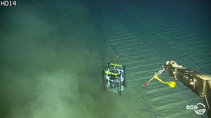 Auf dieser Aufnahme eines Unterwasserroboters ist eine Sedimentwolke zu sehen, die sich quer zu den Abbau-Spuren ausbreitet. Der mit Sensoren ausgestattete Mikroprofiler in der Bildmitte ist etwa so groß wie ein Reisekoffer. 